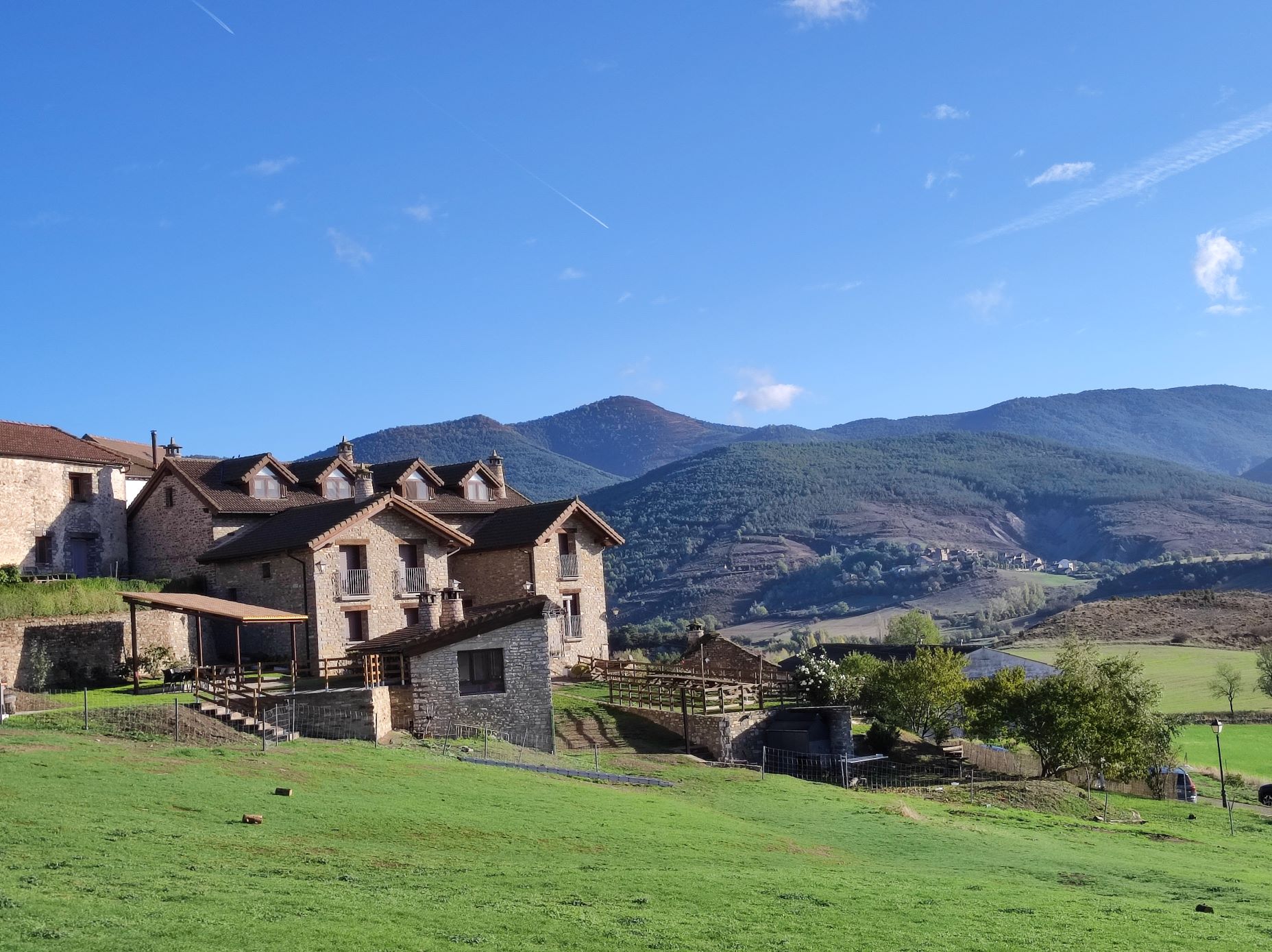 Fachada de la casa rural con el paisaje del Pirineo